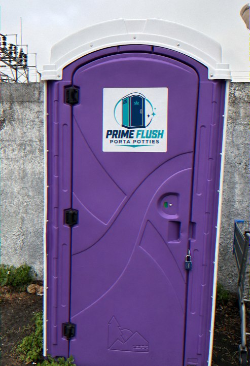 Lockable portable toilet on a construction site beside a concrete wall